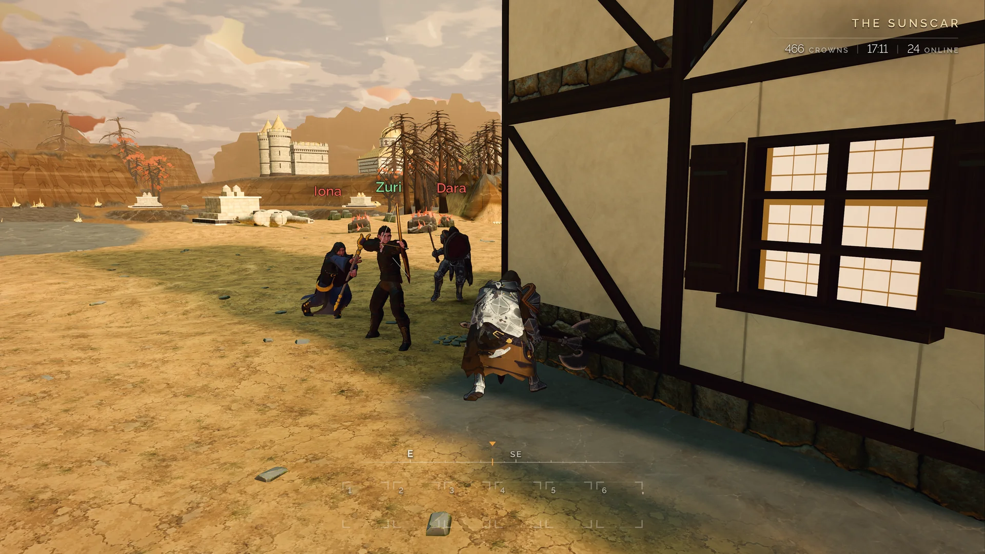Players gather at a timber-framed house overlooking the shore.