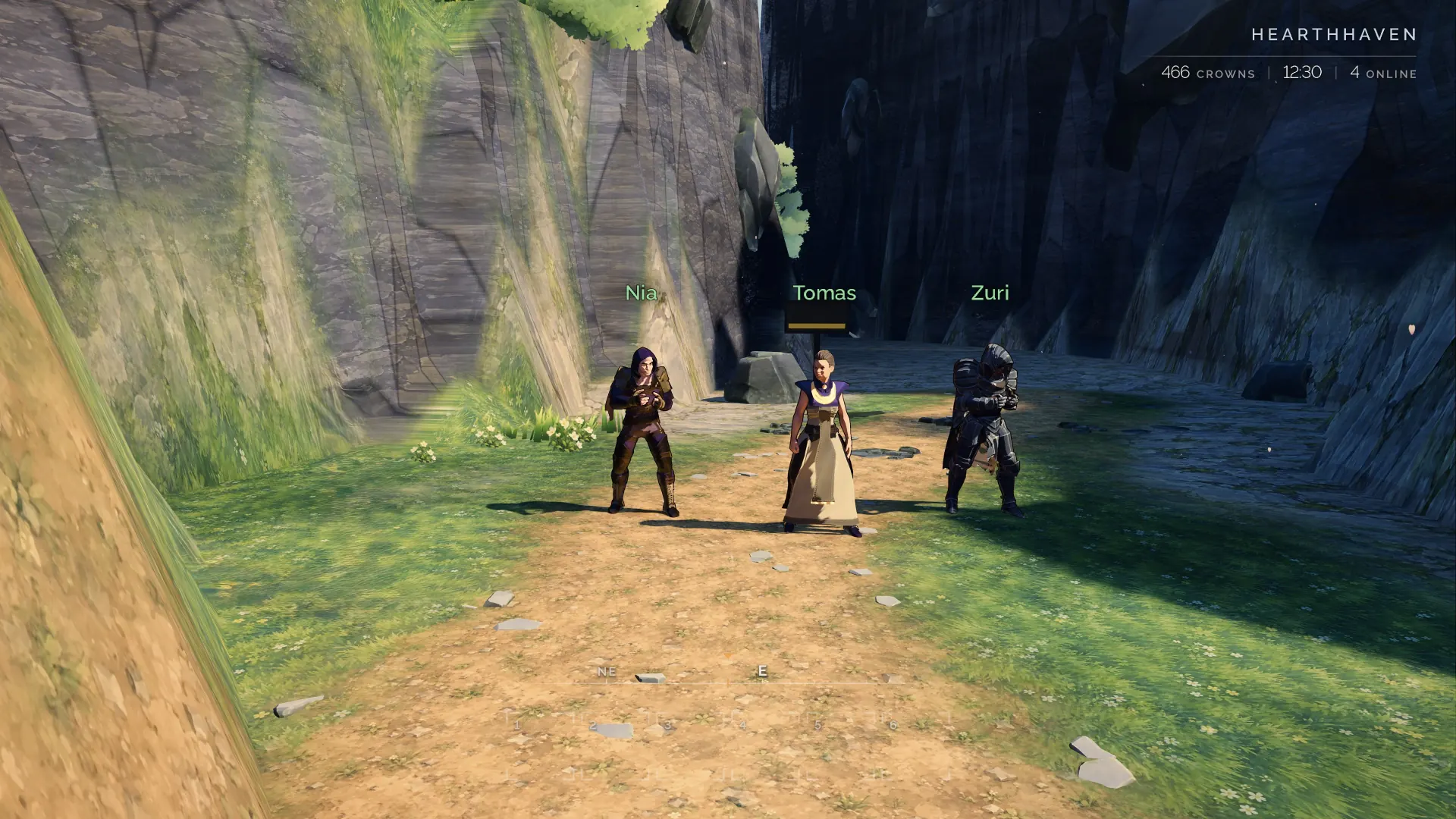 A party pauses on a sunlit path below high cliffs.
